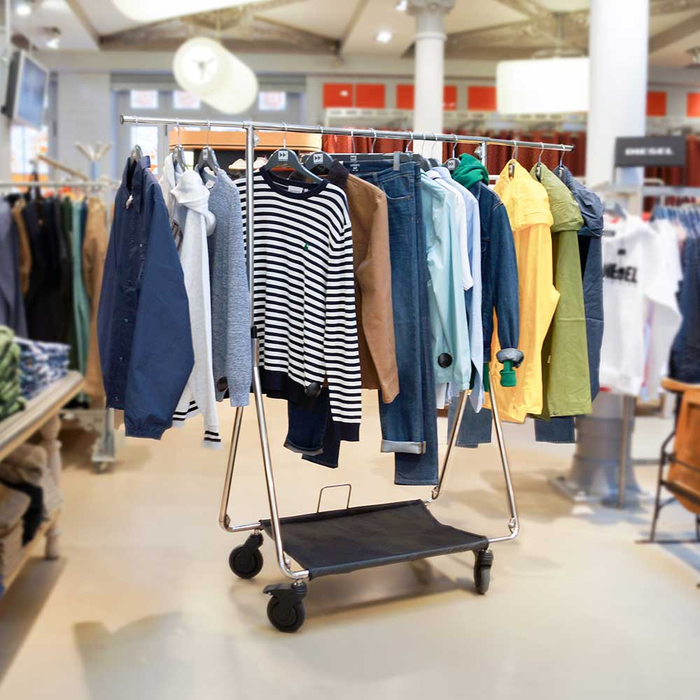 Foldable clothes rack with wheels deployed in a shop